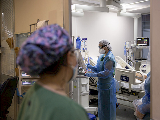 Cama UCI con paciente con COVID-19 rodeado de enfemeras.