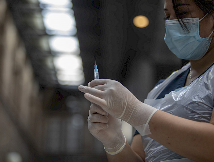 mujer con vacuna en su mano