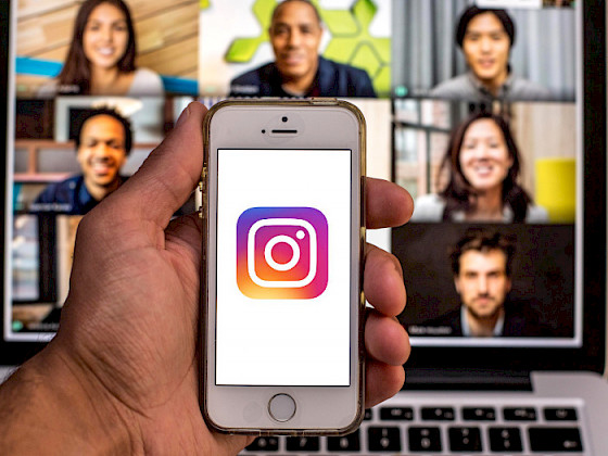 a person holding up an iphone with the instagram logo on it