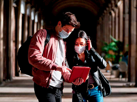 Imagen de dos ex alumnos en Casa Central mirando un documento.