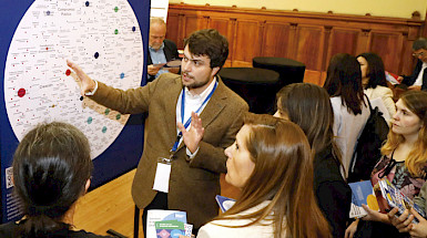 Dos mujeres mirando y tocando el llamado Mapa de Datos UC.