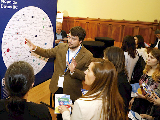 Dos mujeres mirando y tocando el llamado Mapa de Datos UC.