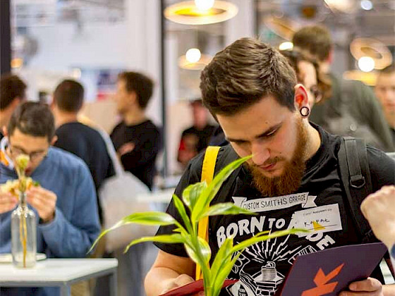 a man reading a book at a table with other people