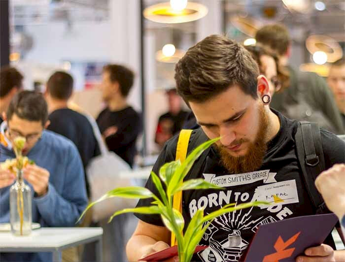 a man reading a book at a table with other people