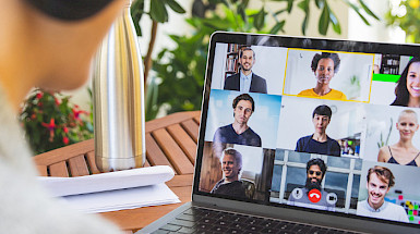 a woman is using a laptop to video chat with other people