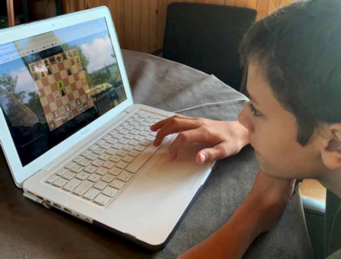 Niño jugando ajedrez en el computador 