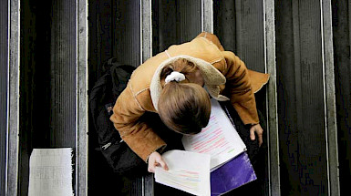 Alumna estudiando en una escalera de uno de los campus de la UC.