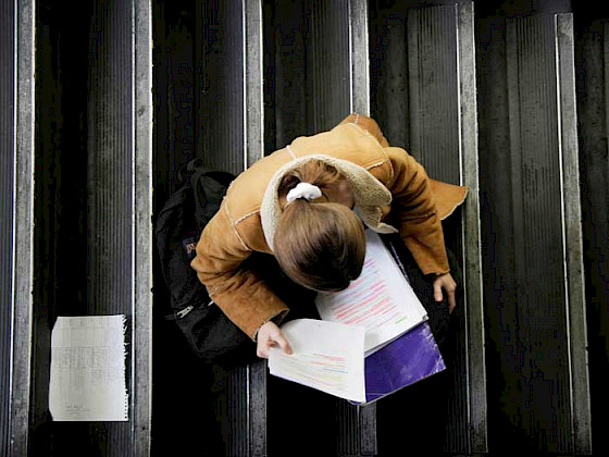 Alumna estudiando en una escalera de uno de los campus de la UC.