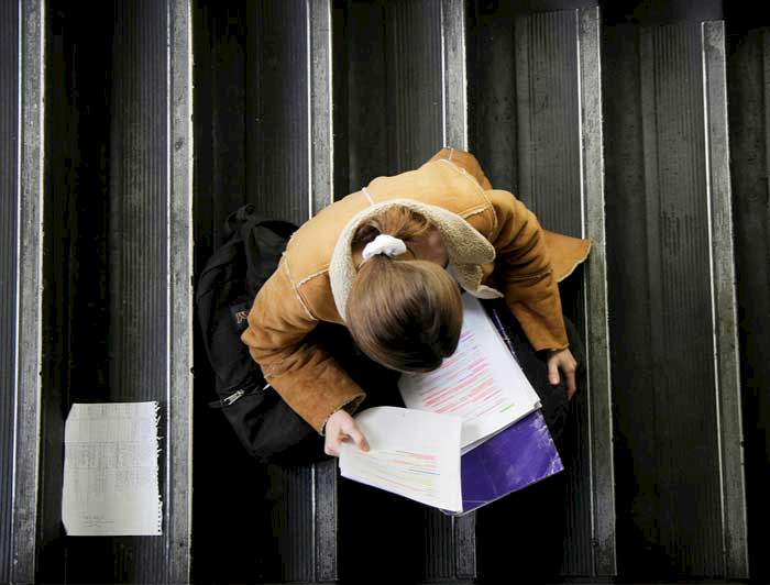 Alumna estudiando en una escalera de uno de los campus de la UC.