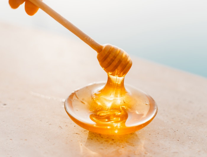 cuchara de madera untada en miel