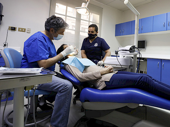 Dentista atendiendo a funcionaria.