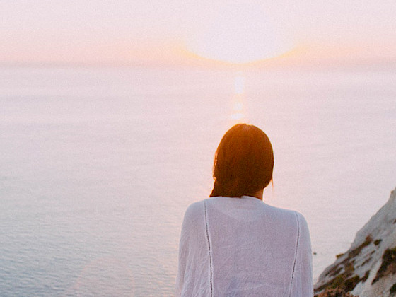 mujer mirando puesta de sol