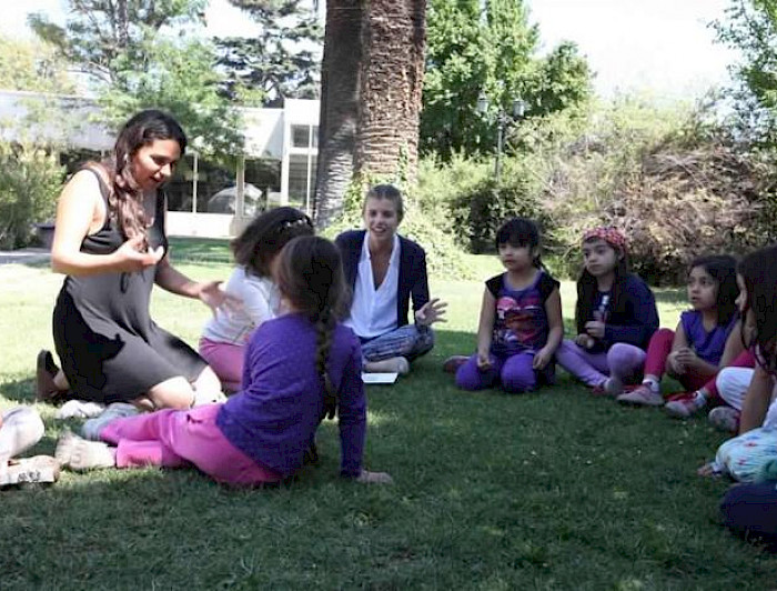 Niños y adultos reunidos y compartiendo en el parque.