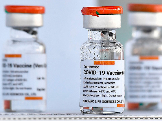 a row of vials with the word covid - 19 vaccine on them