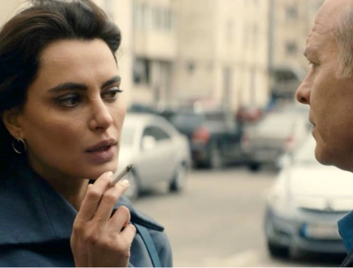 Escena de la película la gomera: una mujer fumando conversa con un hombre.