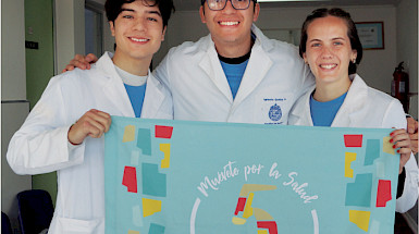 Medical students showing a "Muévete por la salud" poster.