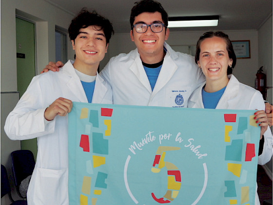 Medical students showing a "Muévete por la salud" poster.