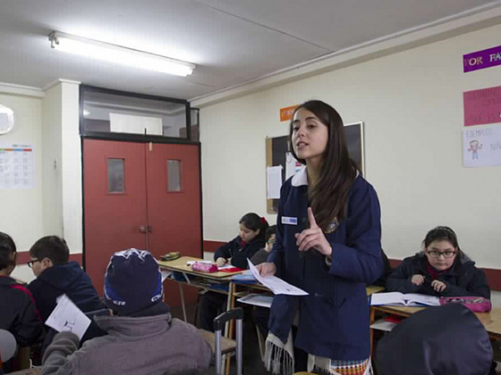 Profesora y estudiantes de pregrado en sala de clases.
