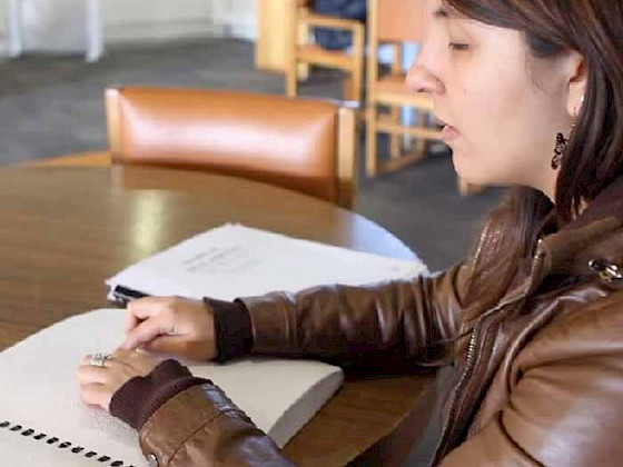 Blind student reading with her fingers.