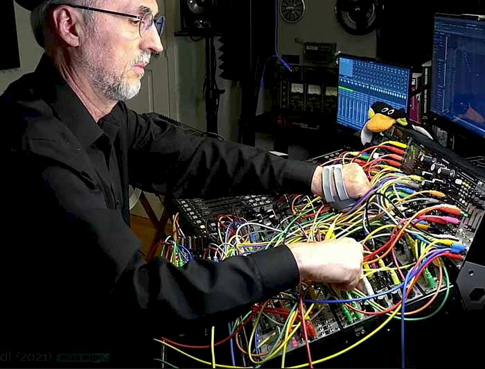 a man working in front of a computer with lots of wires