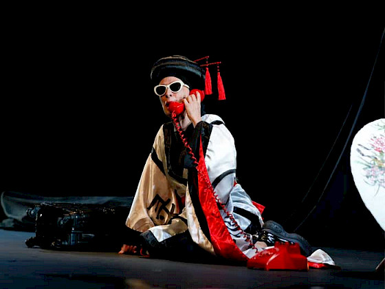 La actriz María Izquierdo, al centro del escenario, vestida con una túnica negra para su nueva obra en Teatro UC.