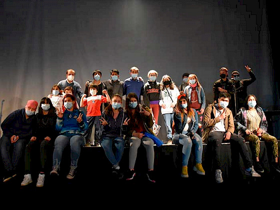 personas sentadas a la orilla de un escenario