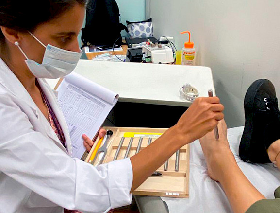 Doctor pricking a patient's foot