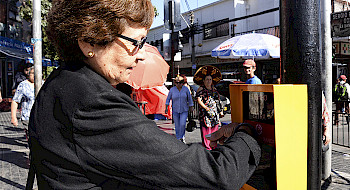Anciana con un braselete en el brazo extiende la luz roja en un semáforo gracias a una tecnología que este último porta ensamblada.