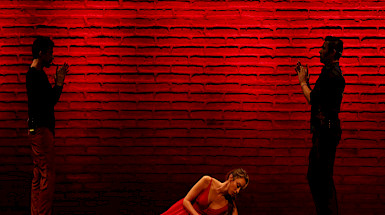 Imagen obra de teatro con fondo rojo.