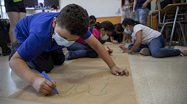 Niño escribiendo en un papelógrafo