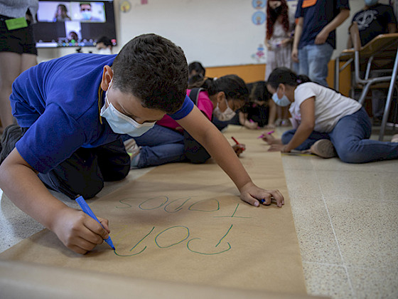 Niño escribiendo en un papelógrafo