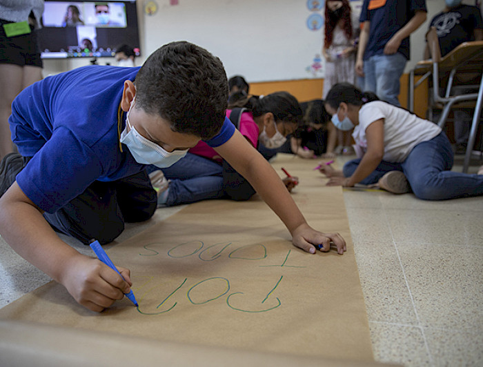 Niño escribiendo en un papelógrafo