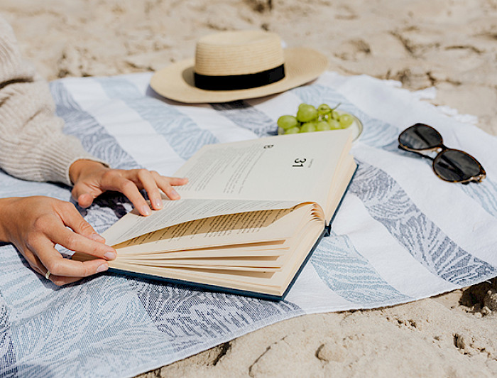 Persona lee un libro en la playa 