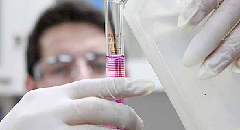Estudiante en un laboratorio sostiene una probeta.