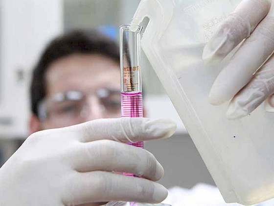 Estudiante en un laboratorio sostiene una probeta.