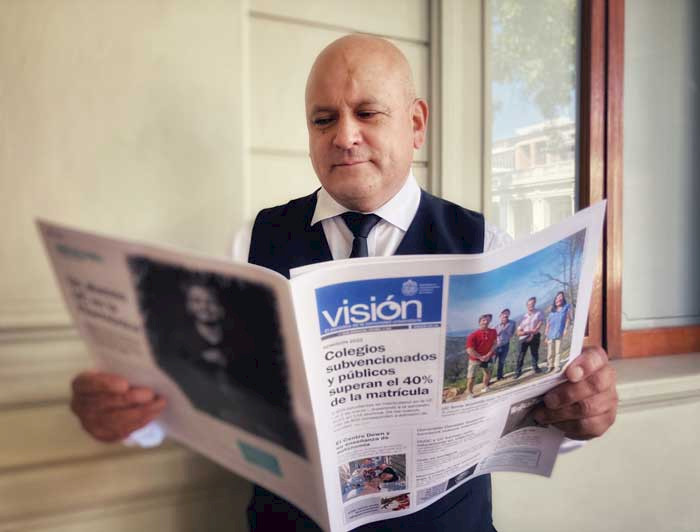 funcionario Luis Iturra leyendo el diario Visión UC en Casa Central.