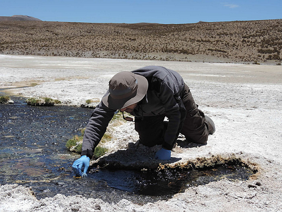 Científico obteniendo una muestra en un río.