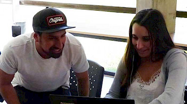 hombre y mujer jóvenes mirando pantalla de computador portatil