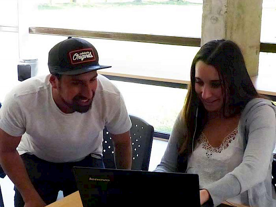 hombre y mujer jóvenes mirando pantalla de computador portatil