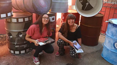 Rashel Vargas e Isabel Wahl junto a envases de aceite industrial