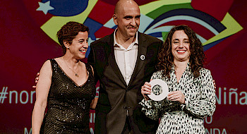 Foto tres personas, dos mujeres y un hombre, en una ceremonia de premiación en España.
