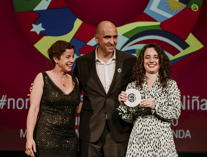 Foto tres personas, dos mujeres y un hombre, en una ceremonia de premiación en España.