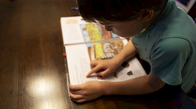 Niño realiza sus tareas escolares en un comedor.