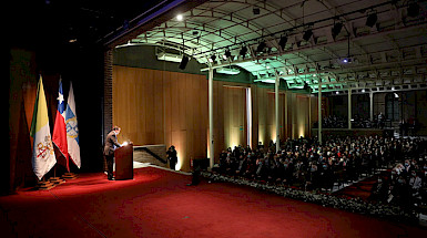 a man standing on stage in front of a large crowd