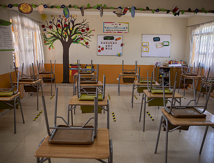 Sala de clases vacía con las sillas sobre las mesas