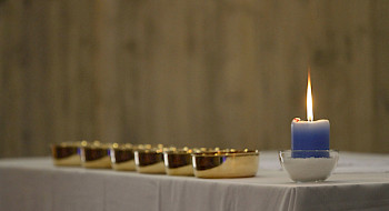 altar con mantel, patenas y vela encendida