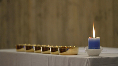 altar con mantel, patenas y vela encendida