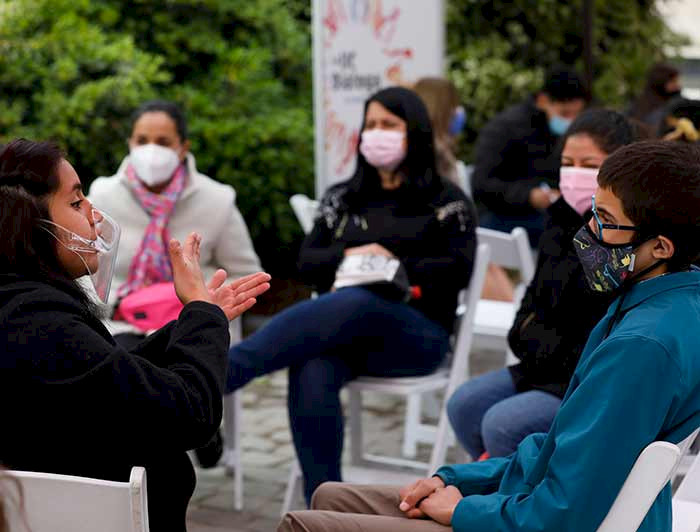 Imagen de un grupo de personas debatiendo al aire libre en uno de los campus. 