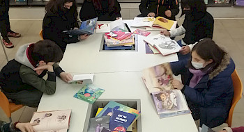 Niñas y niños evaluando libros infantiles en la Biblioteca de Santiago.