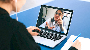 Student talking to another through a screen.